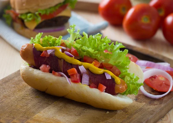 Perrito caliente y tocino servido con tomates de mostaza y un montón de bac —  Fotos de Stock