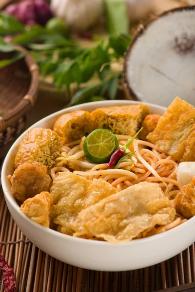 Curry noodle malaysian penang style with raw ingredients on back — Stock Photo, Image