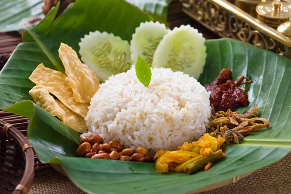 Nasi lemak, a traditional malay curry paste rice dish served on — Stock Photo, Image