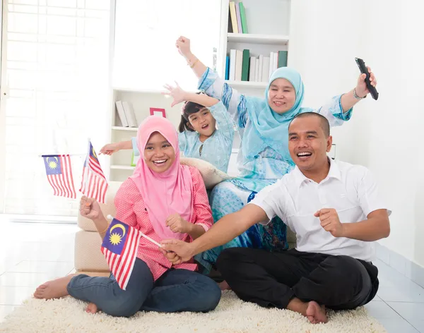 Familia malaya celebrando mientras ve la televisión a través de un a —  Fotos de Stock