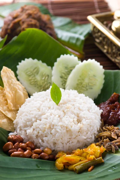 Nasi lemak, a traditional malay curry paste rice dish served on — Stock Photo, Image