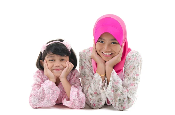 Malay sisters laying on the floor with isolated white background — Stock Photo, Image
