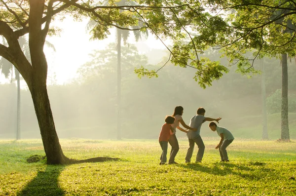 Asyalı bir aile eğleniyor erken sabah parkta oynarken — Stok fotoğraf