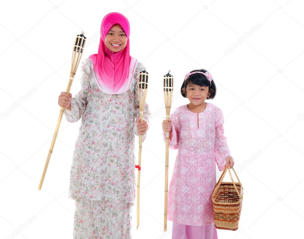 malay sisters with oil lamp during hari raya festival