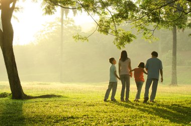 güzel bir su sırasında parkta yürüyen bir aile silüeti