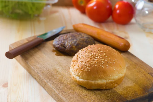 Hamburger fast food ingredients with plenty of raw materials on — Stock Photo, Image