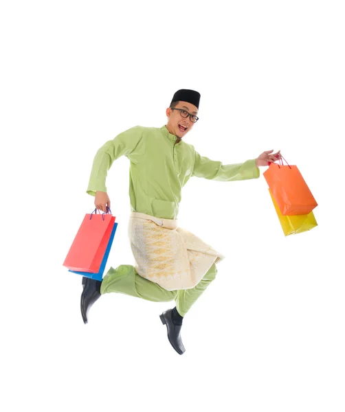 Traditional Malay male shopping and jumping in joy during hari r — Stock Photo, Image