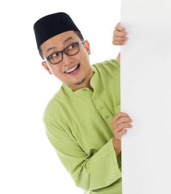 Malay male with blank card during hari raya Eid al-Fitr celebrat clipart