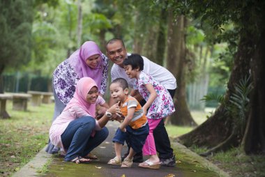 malay Müslüman aile eğleniyor parkta oynarken