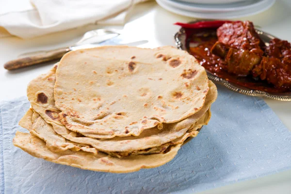 Chapatti roti e comida indiana na mesa de jantar . — Fotografia de Stock