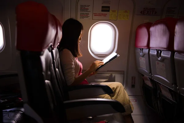 Жінка самотньо подорожує літаком, читаючи на місцях під час — стокове фото