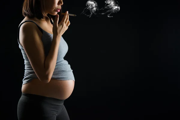 Fumer mère enceinte sur un fond sombre plus dramatique — Photo