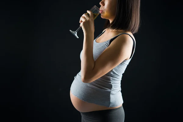 Pití těhotné matky na přes dramatické tmavě lehká poza — Stock fotografie