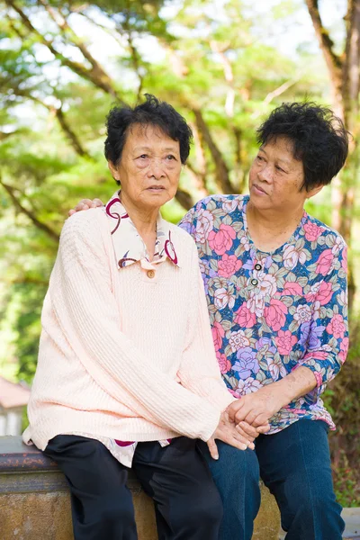 Плачущая старшая азиатская мать со старшей дочерью на открытом воздухе — стоковое фото