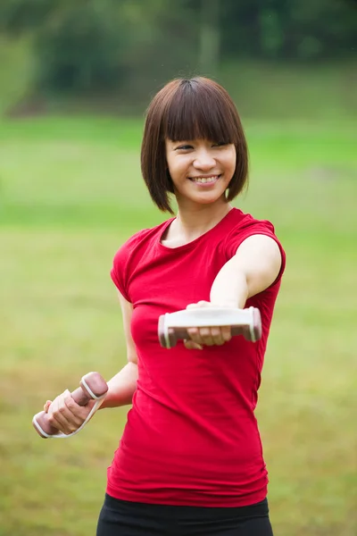 Asiático menina dumbbell treino ao ar livre — Fotografia de Stock