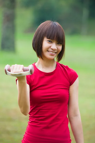 Asiático menina dumbbell treino ao ar livre — Fotografia de Stock