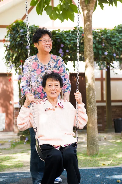 Asian senior enjoying swing in the park — Stock Photo, Image