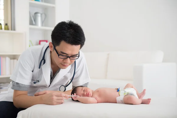 Aziatische mannelijke arts en pasgeboren baby op de kliniek — Stockfoto