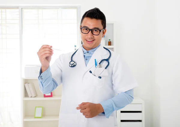 Indonesian male doctor in the clinic with thermometer — Stock Photo, Image