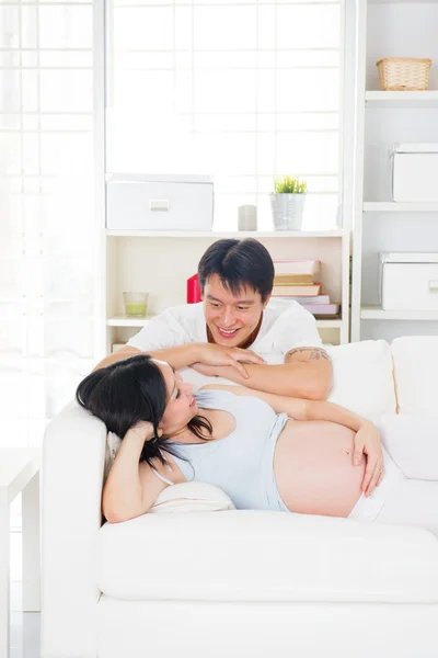 Беременные азиатские муж и жена весело проводят время в гостиной — стоковое фото