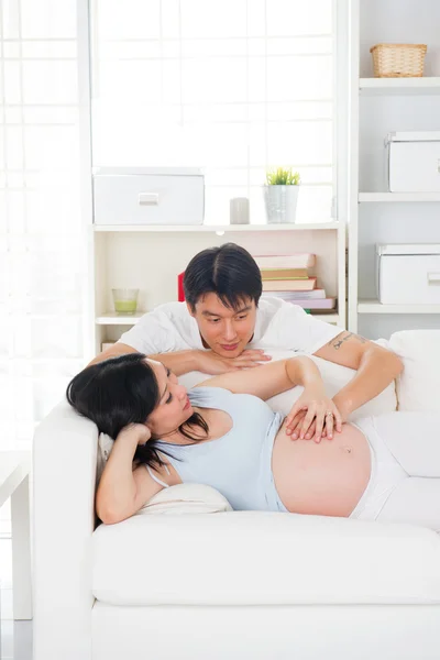 Беременные азиатские муж и жена весело проводят время в гостиной — стоковое фото