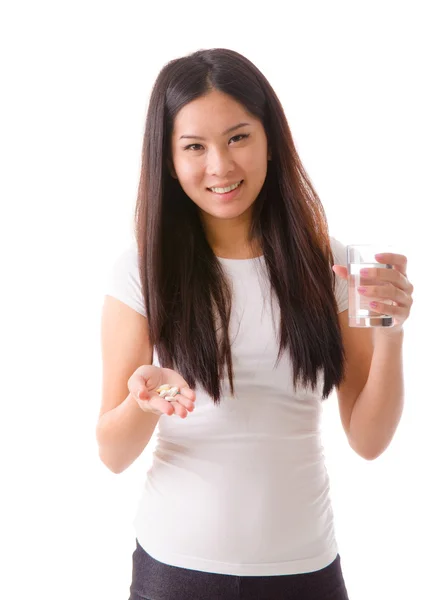 Happy asian girl taking supplement pills — Stock Photo, Image