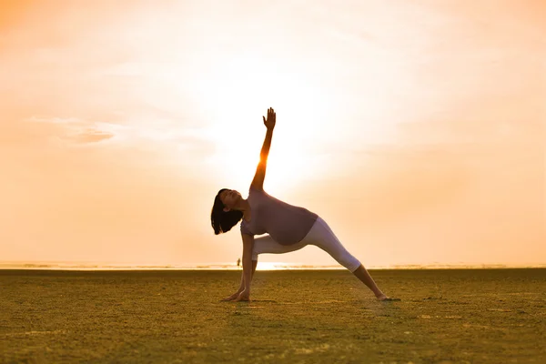 Hamile anne Yoga açık plajda gerçekleştirme — Stok fotoğraf