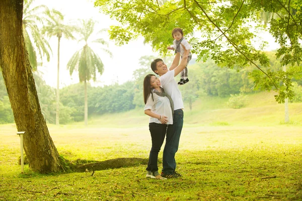 Asiático embarazada madre padre llevar hija al aire libre — Foto de Stock