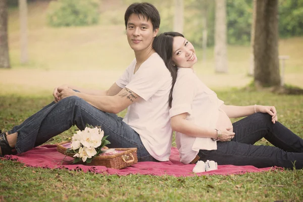 Asiático pai e grávida esposa desfrutando ao ar livre — Fotografia de Stock