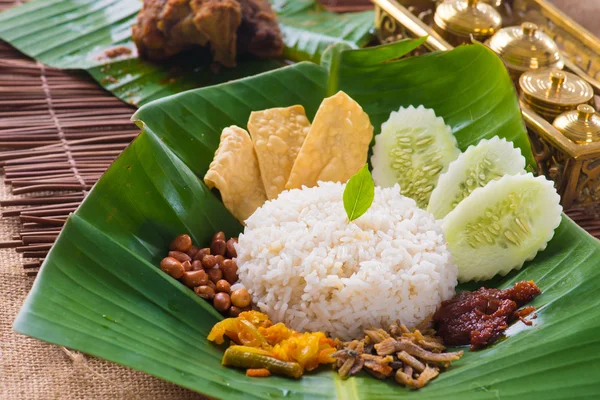 Nasi lemak, a traditional malay curry paste rice dish served on — Stock Photo, Image