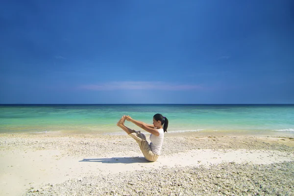Asian female performing beach yoga — Stock Photo, Image
