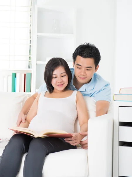 Chinesische schwangere Mutter und Vater lesen — Stockfoto