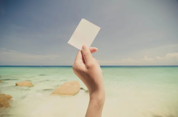 Mão segurando bilhete gratuito para férias na praia estilo vintage — Fotografia de Stock