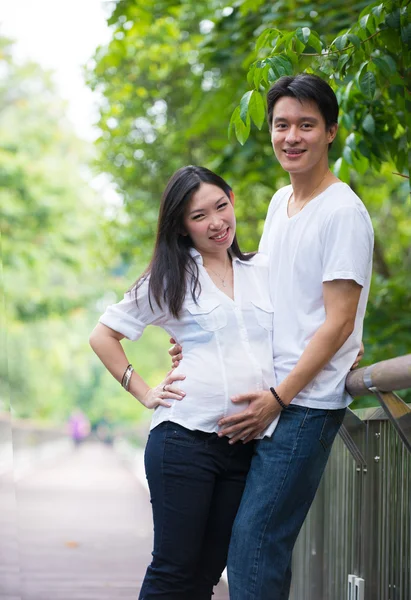 Feliz joven embarazada asiática pareja en la naturaleza —  Fotos de Stock