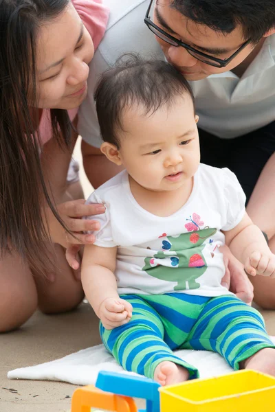 Lycklig asiatiska familj spelar på stranden — Stockfoto