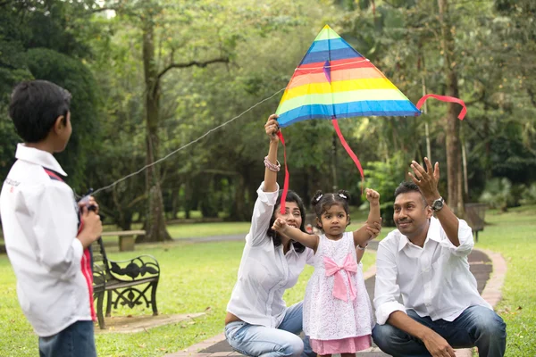 Famiglia indiana giocare aquilone nel parco all'aperto — Foto Stock