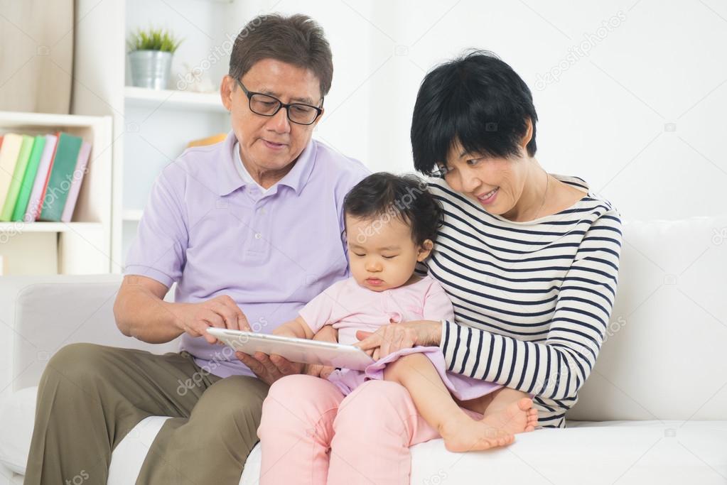 Asian grand parents teaching granddaughter