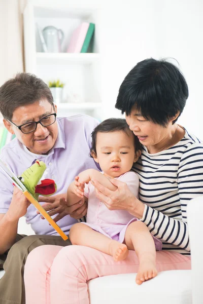 Morföräldrar läsande sagobok till grand dotter — Stockfoto