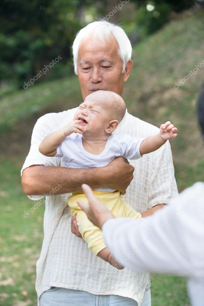 Asian grandparents comforting crying baby