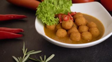 close up footage of curry fish balls with background