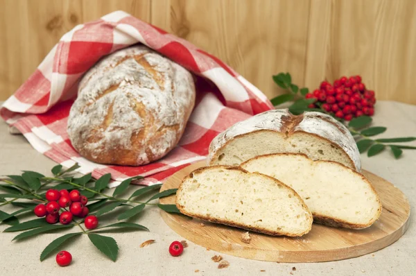 Pane parzialmente affettato di pane su asciugamano e sorbo — Foto Stock
