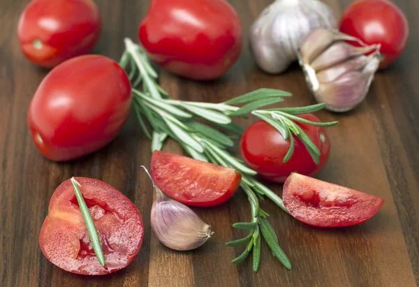 Fresh tomatoes, rosemary and garlic. Selected focus — Stock Photo, Image
