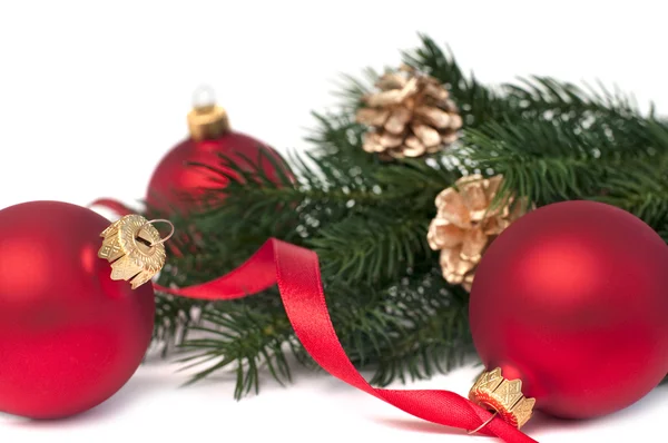 Tři červené vánoční koule a jedle, izolované na bílém — Stock fotografie