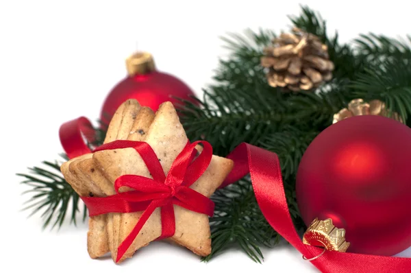 Deux boules de Noël rouges avec ruban doré et biscuits, isolées sur fond blanc, mise au point sélective — Photo