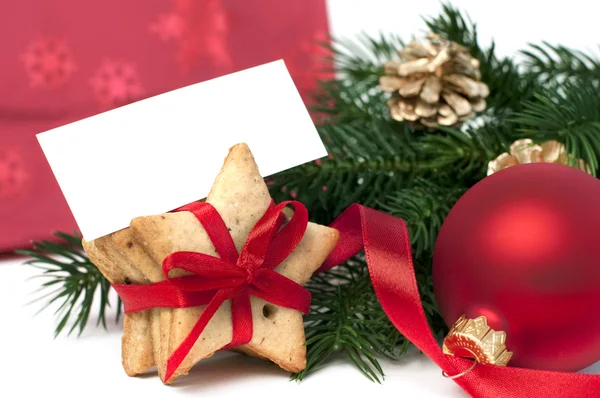 Rama de abeto y galletas de Navidad con tarjeta en blanco, aisladas en blanco, enfoque selectivo —  Fotos de Stock