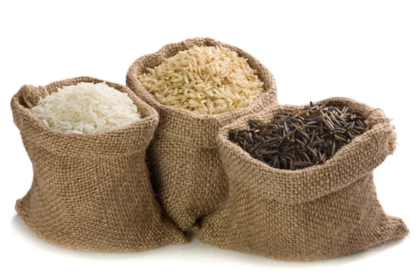 Uncooked rice in small burlap sacks — Stock Photo, Image