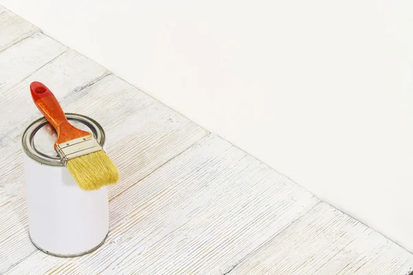 Малювати пензлик і банку, фарбувати пензлик і білий колір контейнера на дерев'яному фоні підлоги — стокове фото