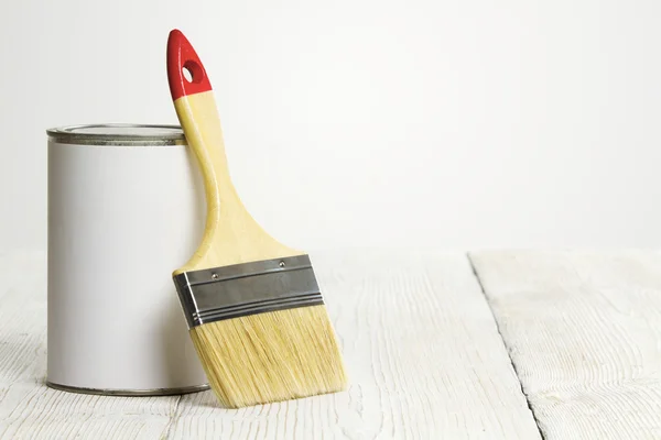 Pincel y lata, pincel de pintura y recipiente de color blanco sobre fondo de madera —  Fotos de Stock