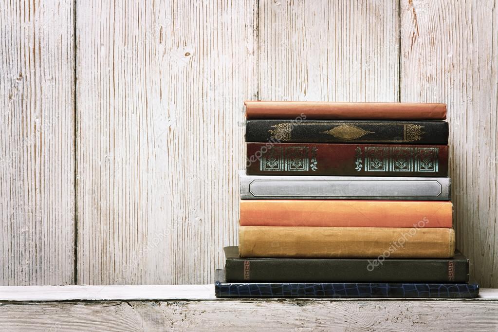 Old book shelf blank spines, empty binding stack on wood texture background, knowledge concept