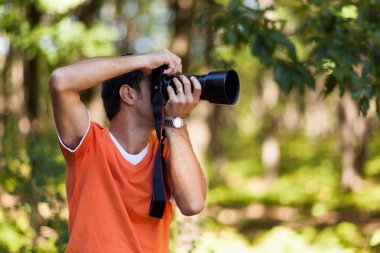 genç adam ormanda fotoğraf çekmek